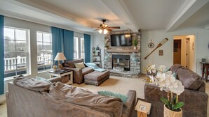 A spacious living room with a fireplace, comfortable seating, and a television. - Private Hot Tub! Getaway on Smith Mountain Lake (Goodview)