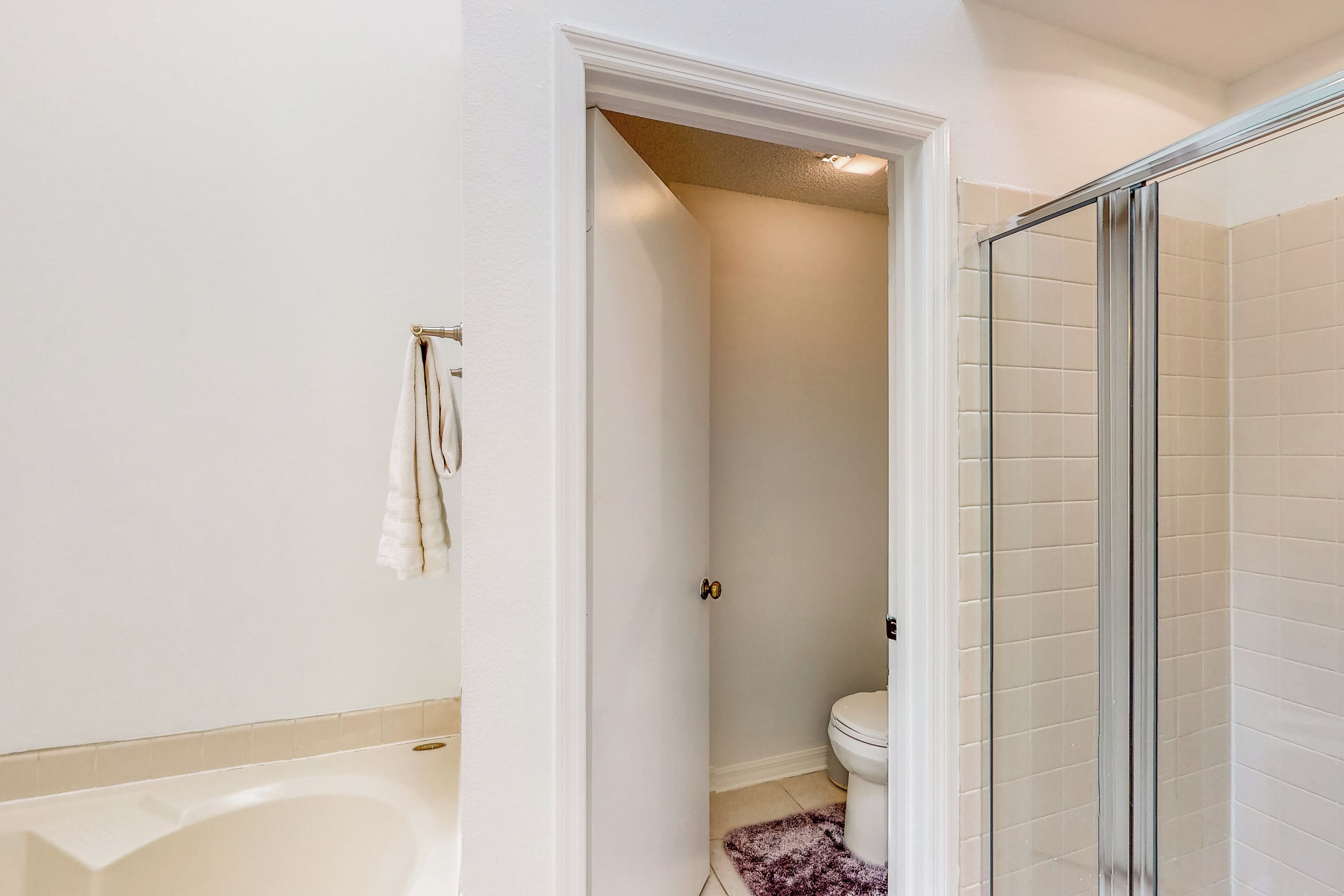 Ein Badezimmer mit Badewanne, Toilette und Duschkabine aus Glas.