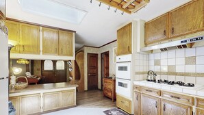 Una cocina con armarios de madera, estufa y refrigerador.
