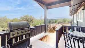 A covered outdoor area with a grill, a table, and chairs. - Buckthorn Beauty: Golf, Hike & More (Show Low)