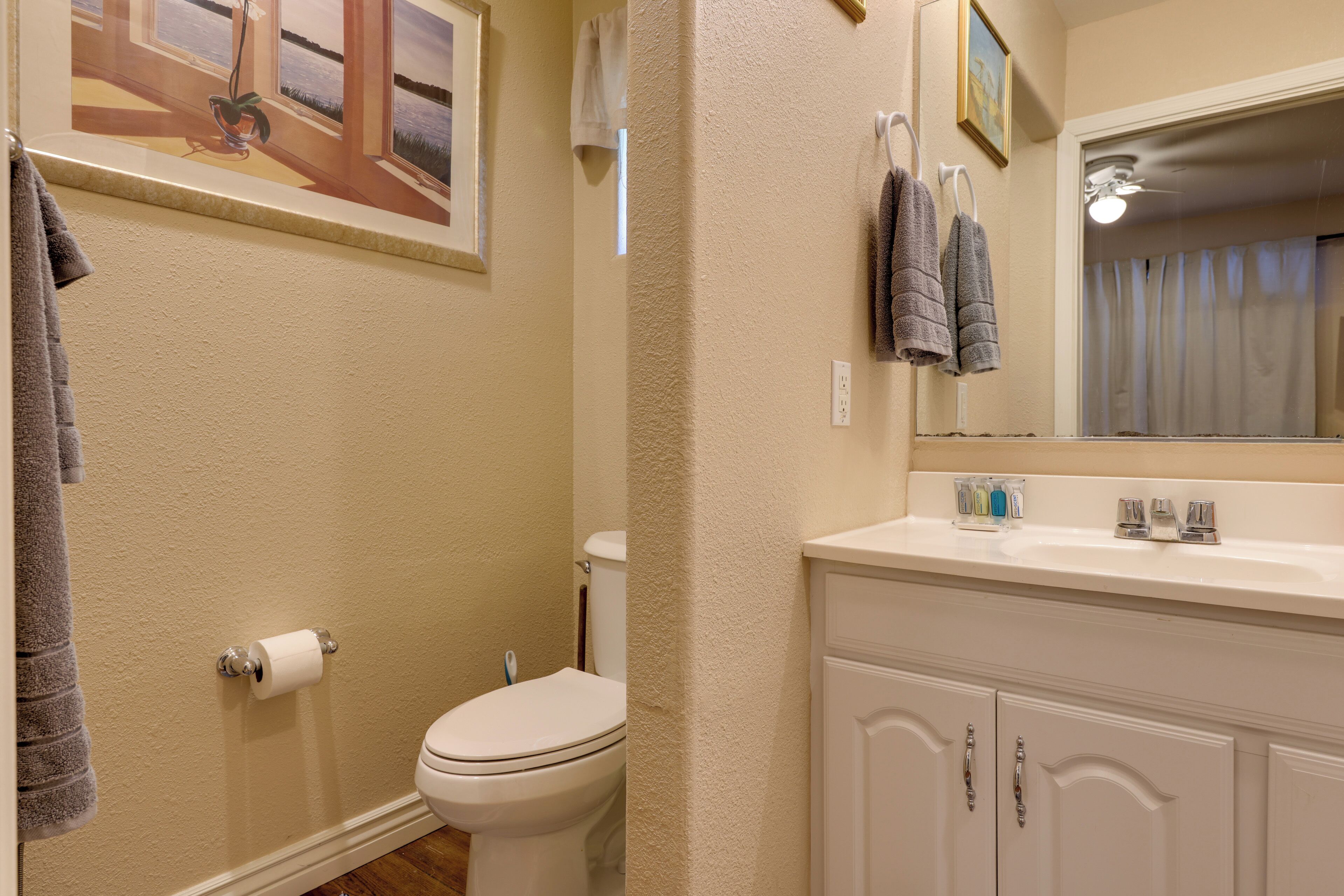 A bathroom with a toilet, sink, and towel rack.