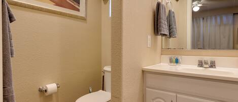 A bathroom with a toilet, sink, and towel rack.