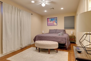A bedroom with a bed, an ottoman, a nightstand, a lamp, and a ceiling fan. - Near Parks, Shops & Eats! Bullhead City Casita (Bullhead City)