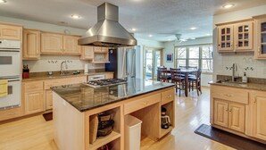 A modern kitchen with wooden cabinets, a central island, and built-in appliances. - Waterfront Alexandria Gem: Family & Group Friendly (Alexandria)