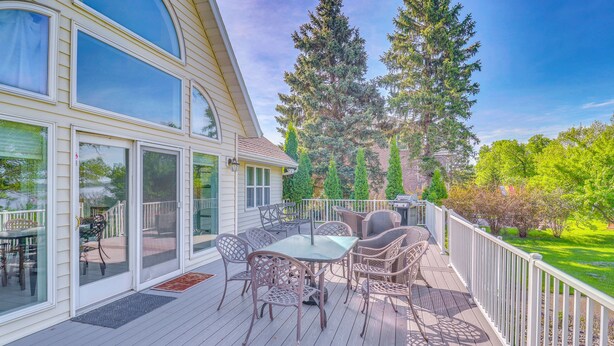 A covered deck with outdoor furniture, large windows, and a view of trees and a house. - Waterfront Alexandria Gem: Family & Group Friendly (Alexandria)