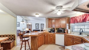 A kitchen with wooden cabinets, a microwave, and a dishwasher. - Countryside Haven w/ Spacious Yard in Tamassee! (Tamassee)