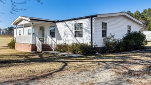A single-story house with a front porch, a small staircase, and a gravel driveway. - Countryside Haven w/ Spacious Yard in Tamassee! (Tamassee)