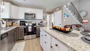 A modern kitchen with stainless steel appliances, white cabinetry, and a granite countertop. - Gateway to Fort Campbell! Home w/ Furnished Deck (Clarksville)