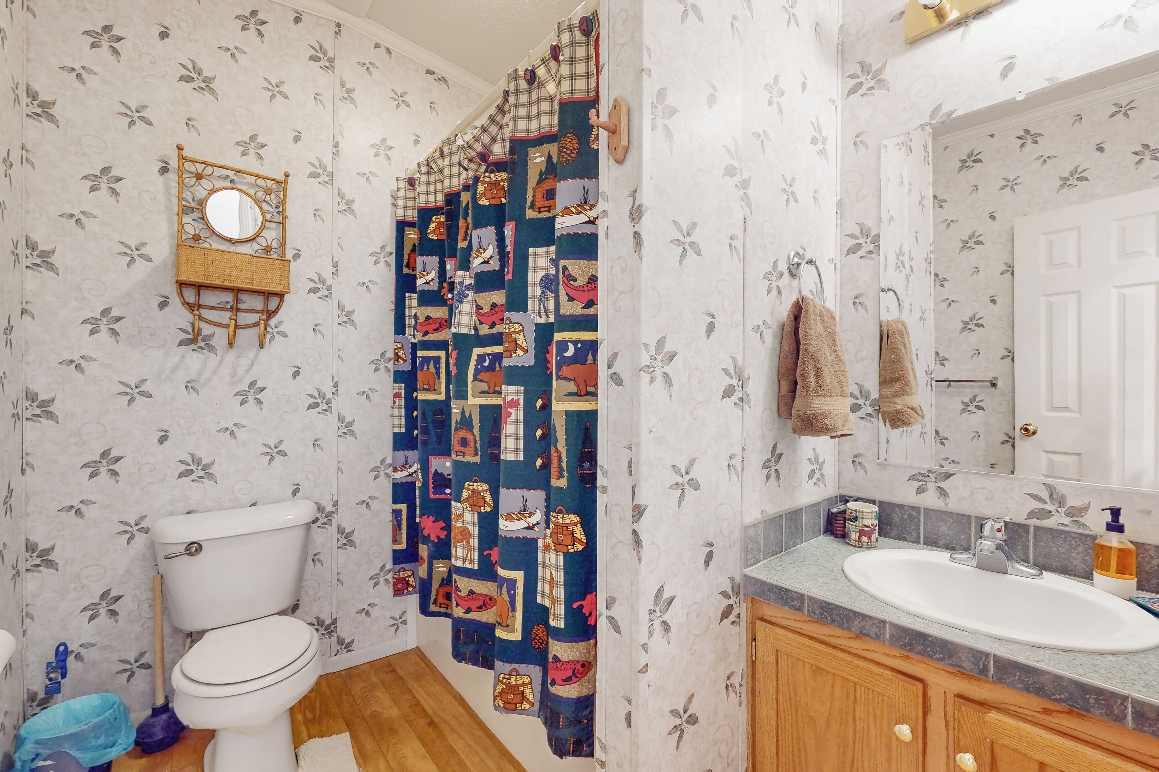 A bathroom with a toilet, a sink, and a shower curtain with a geometric pattern.