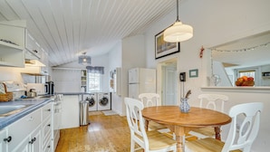 A kitchen with white cabinets, a wooden dining table, and chairs. There is a washing machine and a refrigerator. - 12 Mi to Bromley Mtn Ski Resort: Quiet Hideaway (Manchester Center)