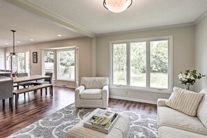 A spacious living room with a dining area, large windows, and a cozy seating arrangement. - Plymouth House: Walk to Beach & Medicine Lake! (Plymouth)