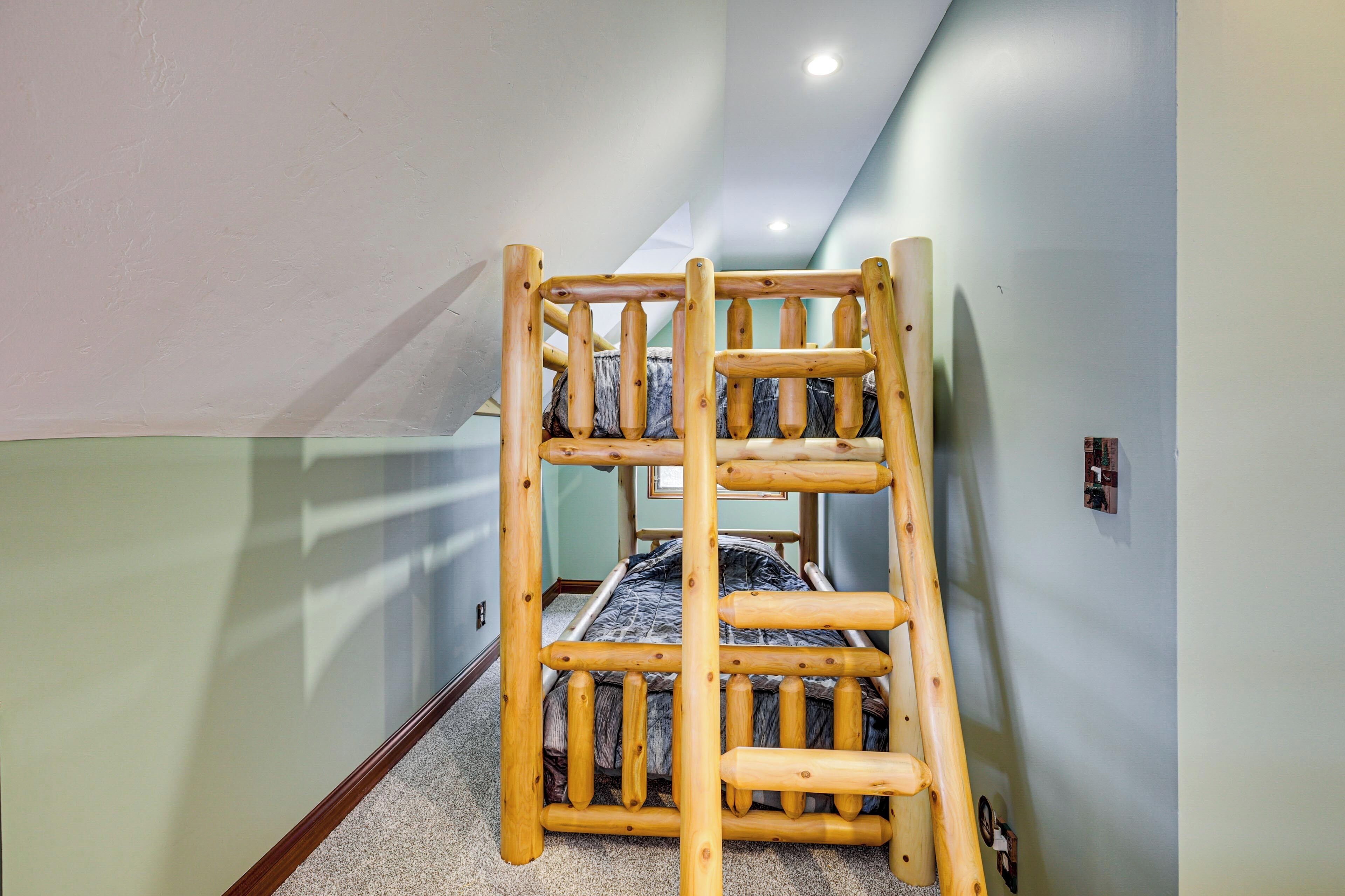 Un lit superposé dans une pièce avec un plafond en pente et une fenêtre bien visible.