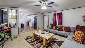 A living room with a sofa, coffee table, and a ceiling fan. - Private Pool! Nat'l Forest Retreat on 1 Acre (Oakhurst)