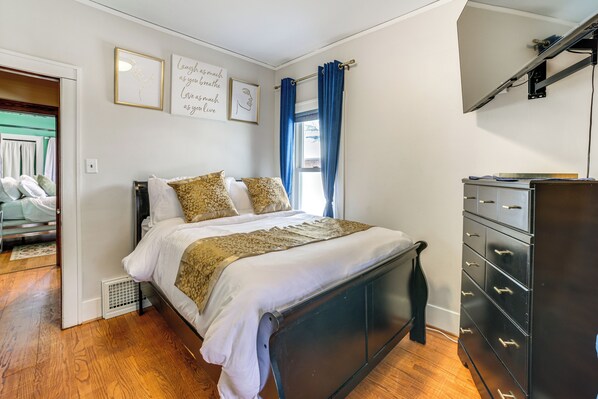 A bedroom with a bed, a dresser, and a window with curtains. - Private Hot Tub & Patio! Chicagoland Extended Stay (Lansing)