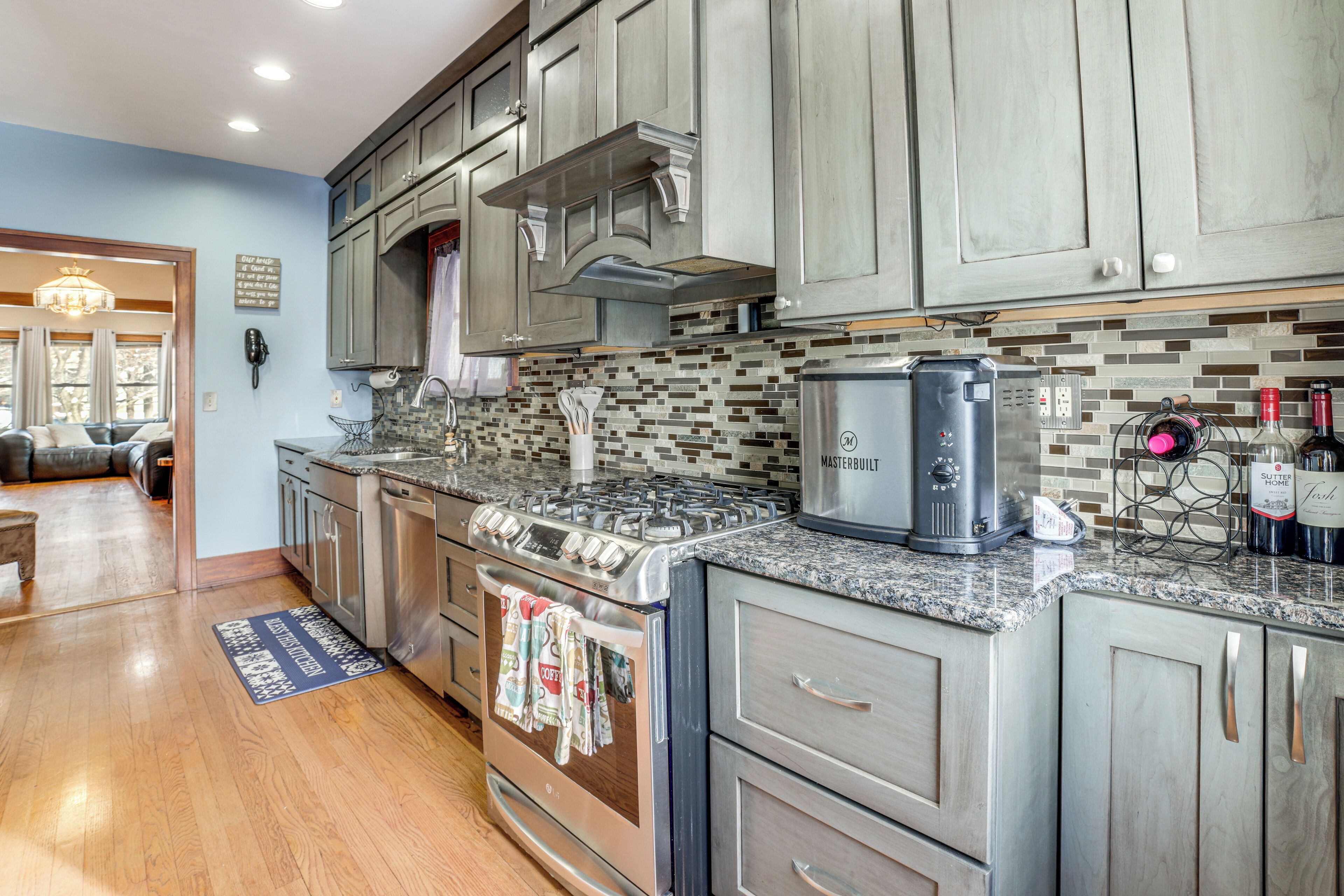 A kitchen with granite countertops, stainless steel appliances, and wooden cabinets.