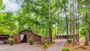 Un chalet rustique aux murs en bois, entouré d’une forêt dense et verdoyante.
