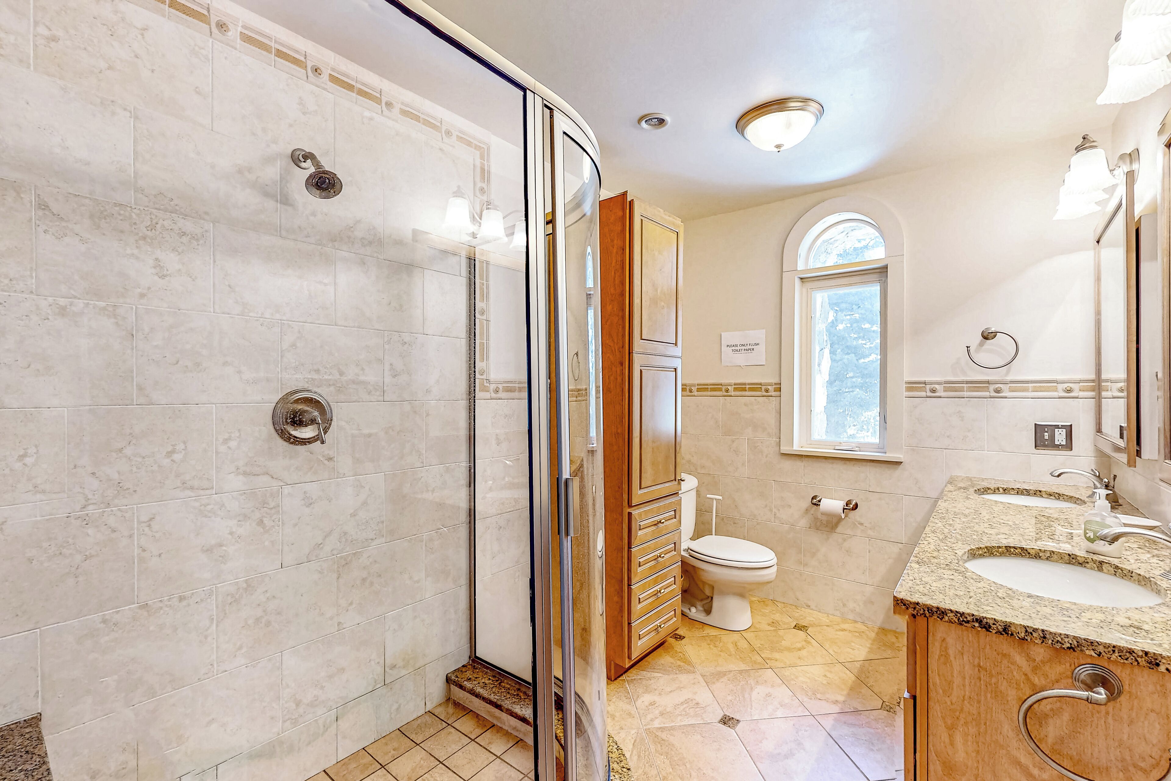 Une salle de bain moderne avec une douche à parois de verre, un meuble-lavabo en bois et des toilettes.