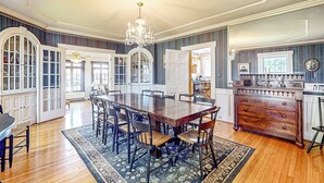 A dining room with a large wooden table, chairs, and a chandelier. - 7BR Modern Farmhouse on Sustainable Working Farm (Ballston Lake)