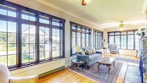 A spacious living room with large windows, a fireplace, and a cozy seating area. - 7BR Modern Farmhouse on Sustainable Working Farm (Ballston Lake)