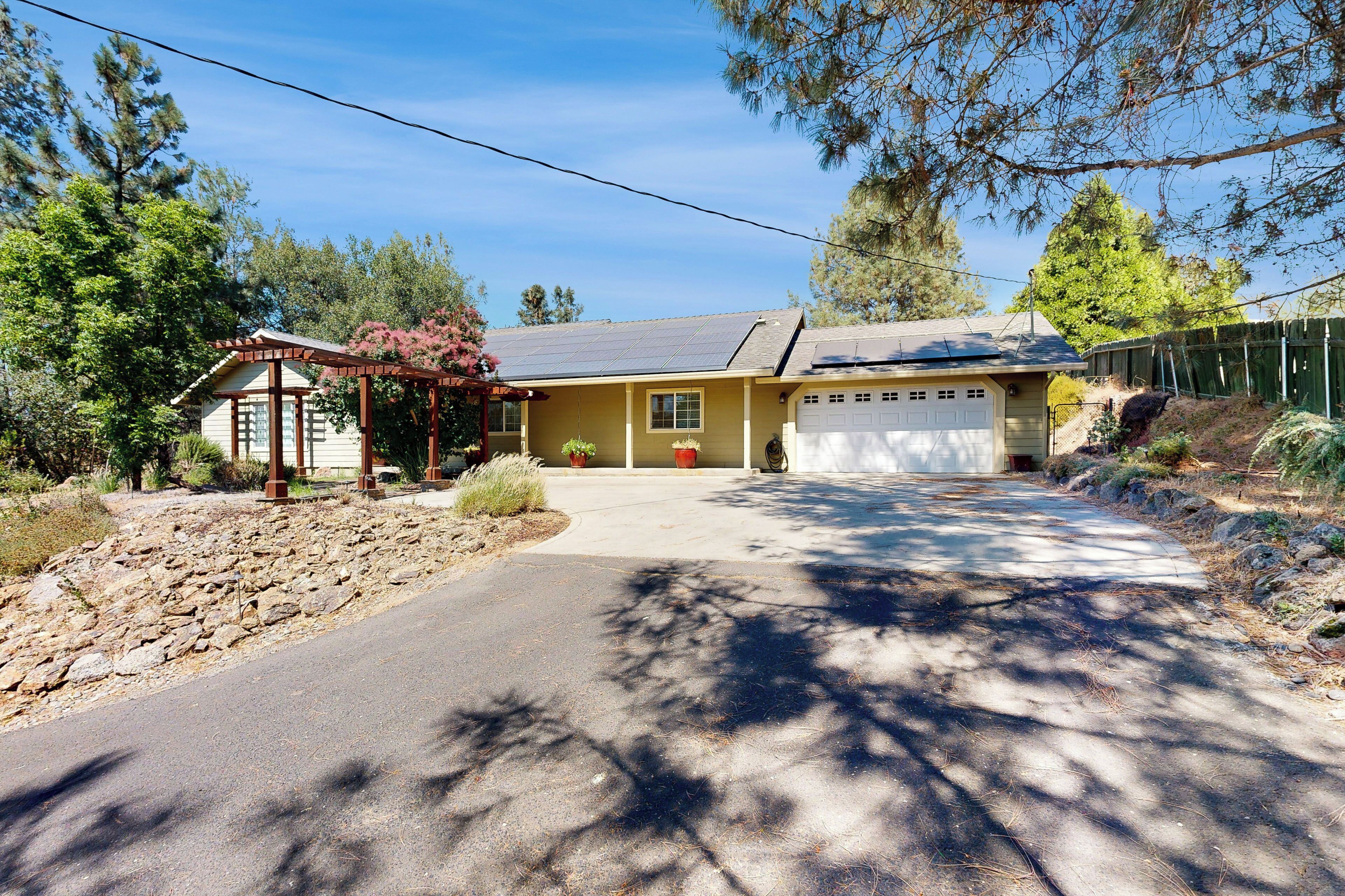 A two-story house with a garage, a covered porch, and a driveway leading to the garage.