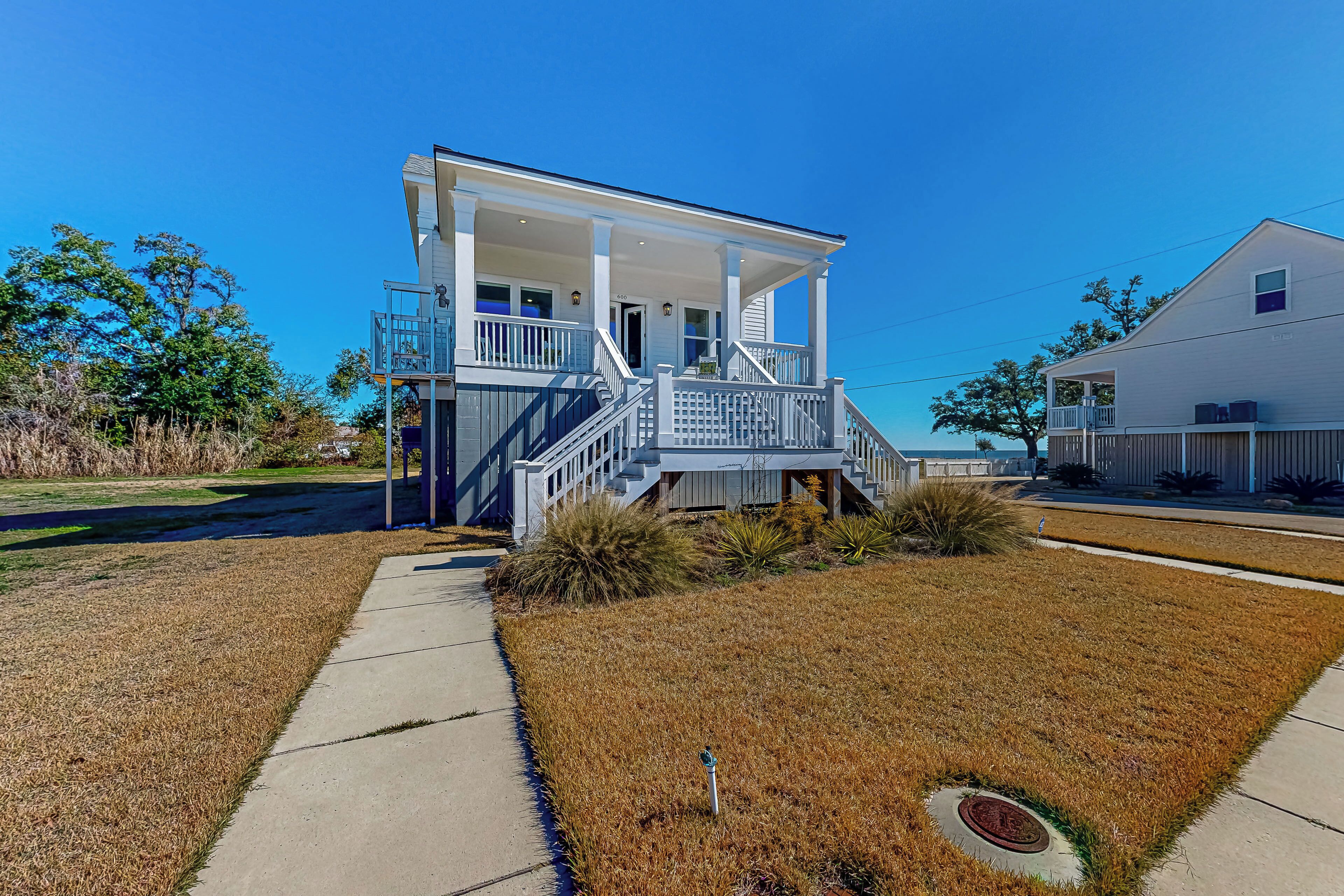 A two-story house with a front porch, a staircase, and a small garden area.