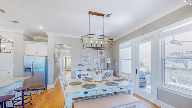 A modern kitchen with a central island, a built-in refrigerator, and a large window offering a view of the outdoors. - 3BR Home Near Beach w/ Views, Deck & Grill (Gulfport)