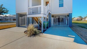 A two-story house with a balcony, a covered front porch, and a fenced yard. - 3BR Home Near Beach w/ Views, Deck & Grill (Gulfport)