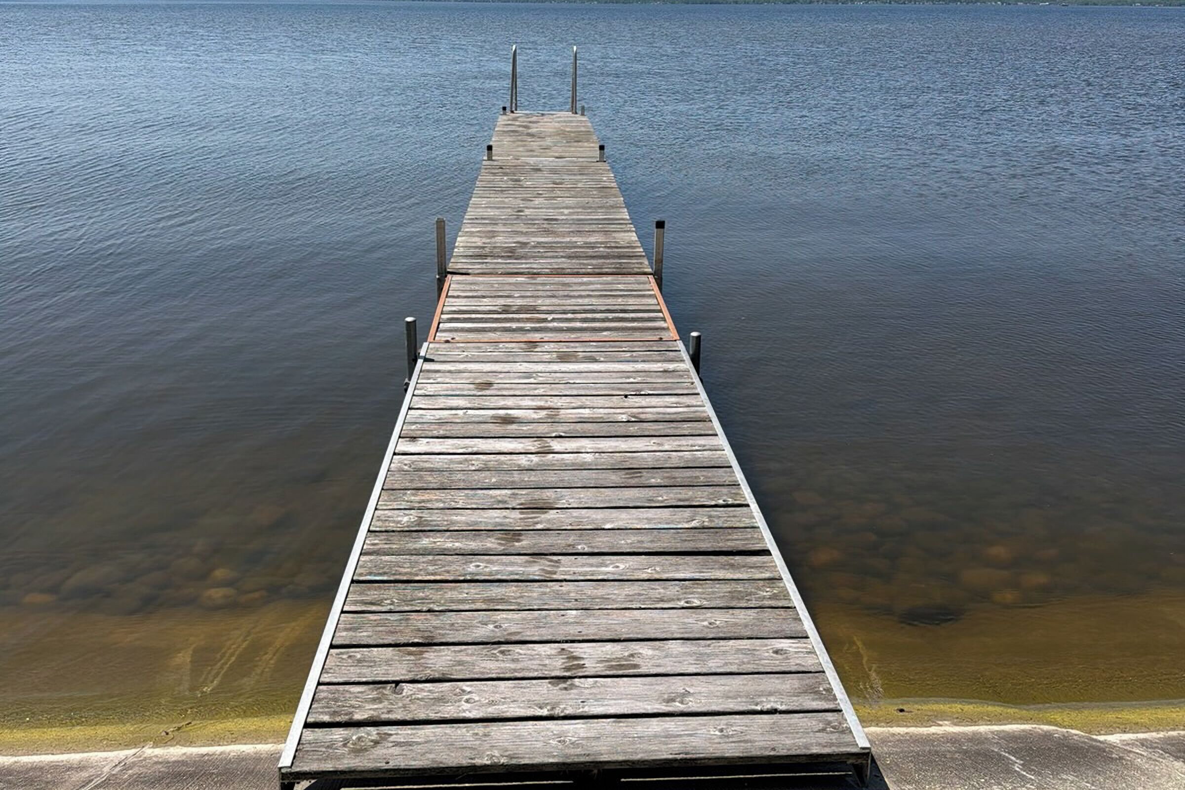Een houten steiger die zich uitstrekt over kalm water.