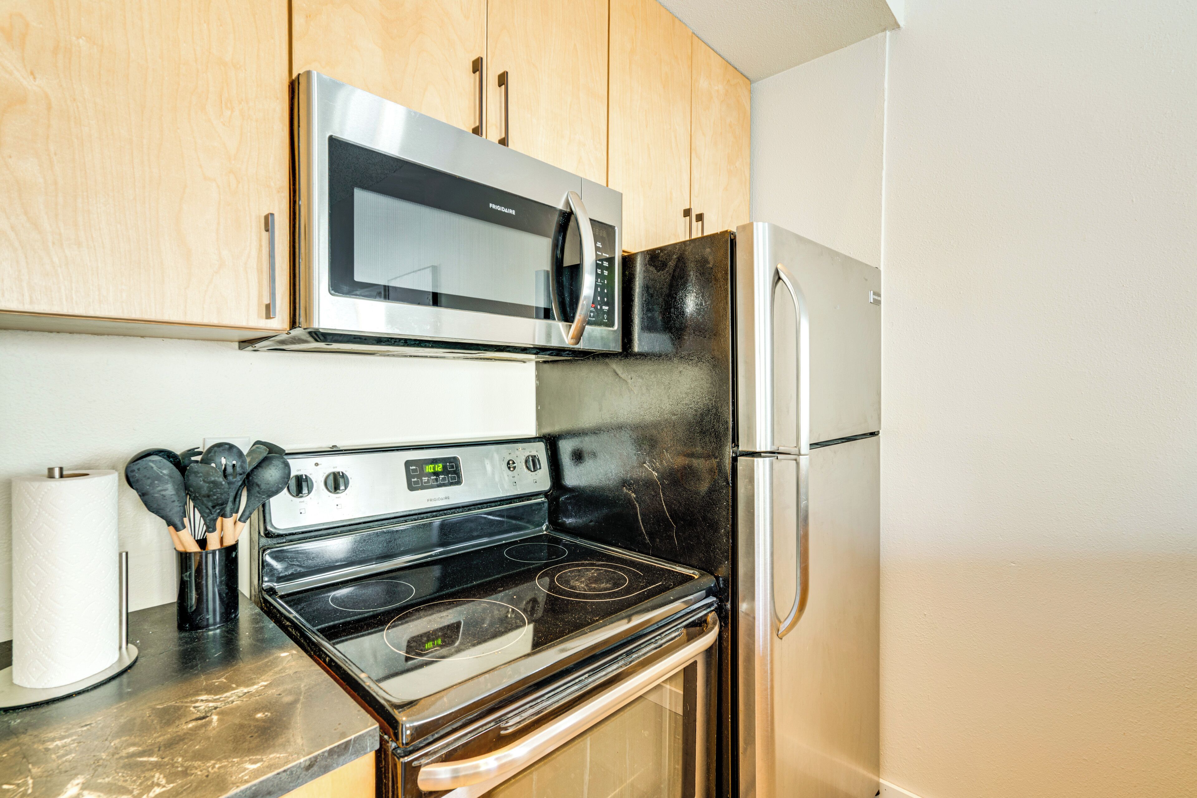 A kitchen with a stainless steel microwave, oven, and refrigerator.
