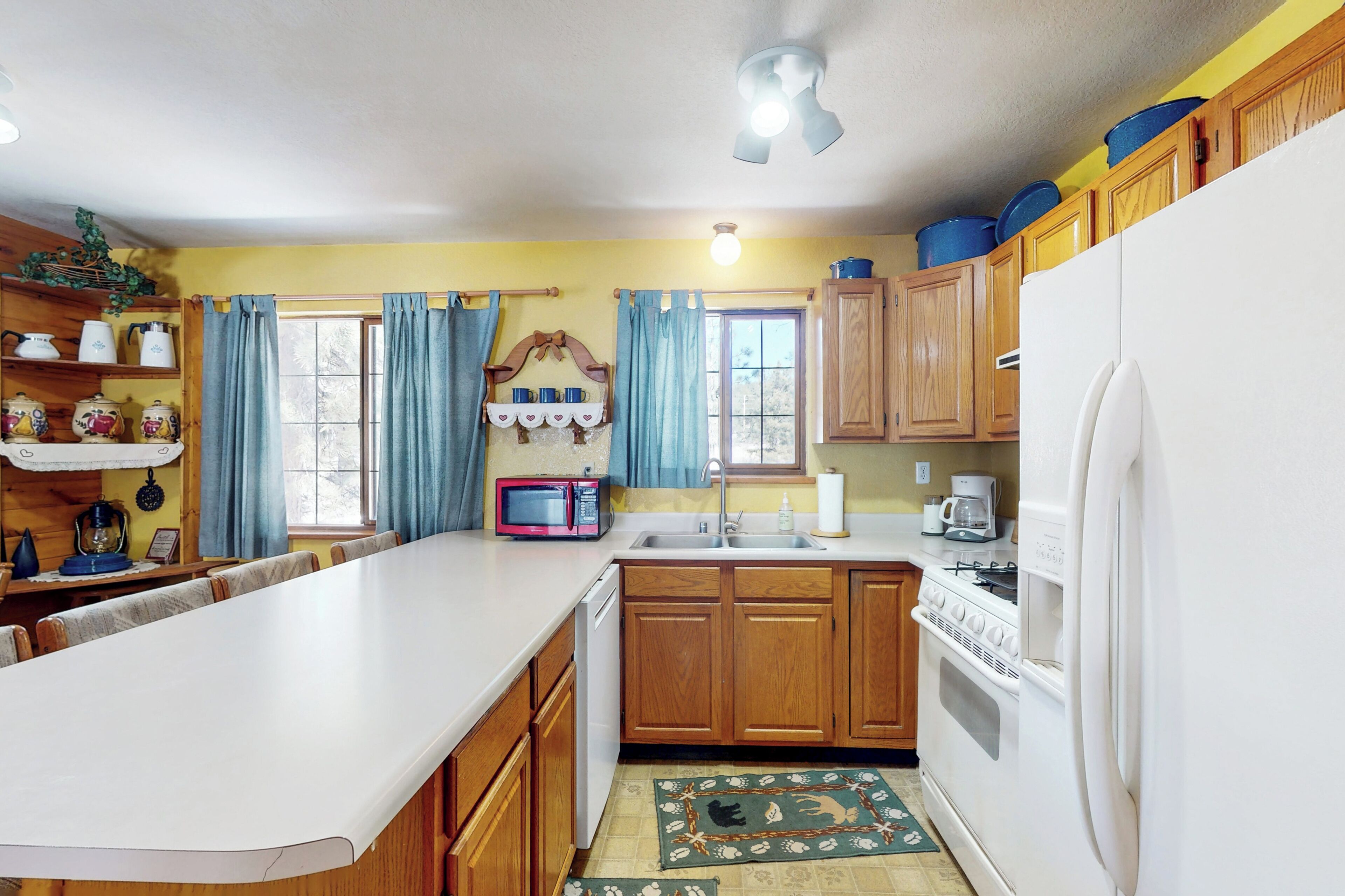A kitchen with wooden cabinets, a white refrigerator, a microwave, and a stove.