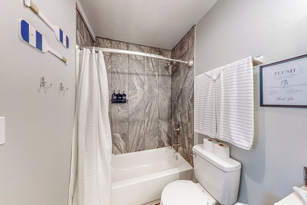 A bathroom with a bathtub, toilet, and shower curtain. - Steps to Lake Eufaula: Home w/ Fire Pit & BBQ (Eufaula)