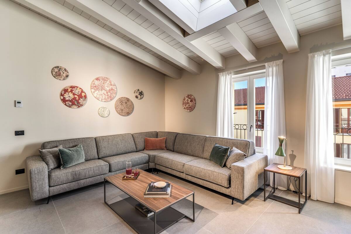 A modern living room with a sectional sofa, a coffee table, and decorative wall art.