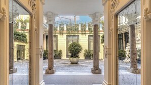 A grand entrance with classical columns, a central potted plant, and a cobblestone courtyard. - Seety Spartaco (Milan)