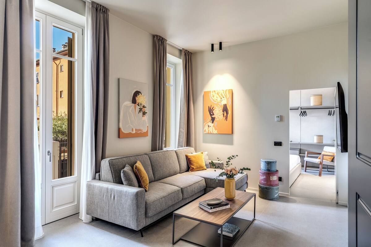 A modern living room with a grey sofa, a coffee table, and artwork on the walls.