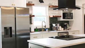 Een moderne keuken met roestvrijstalen apparatuur, een groot raam en een magnetron.