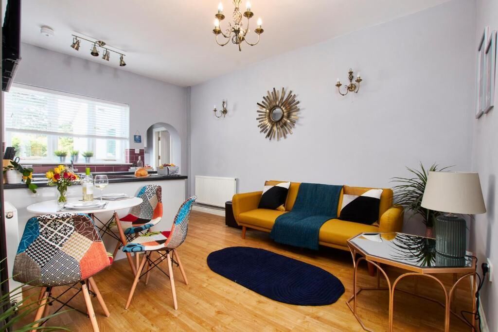 Ein modernes Wohnzimmer mit einer Couch, Sesseln, einem Couchtisch und einer Chandelier.