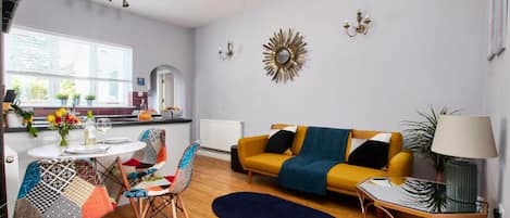 Ein modernes Wohnzimmer mit einer Couch, Sesseln, einem Couchtisch und einer Chandelier.