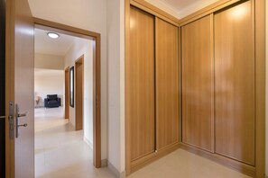 Ein Flur mit einem Holzschrank, einer Tür mit Griff und einer Leuchte an der Decke.