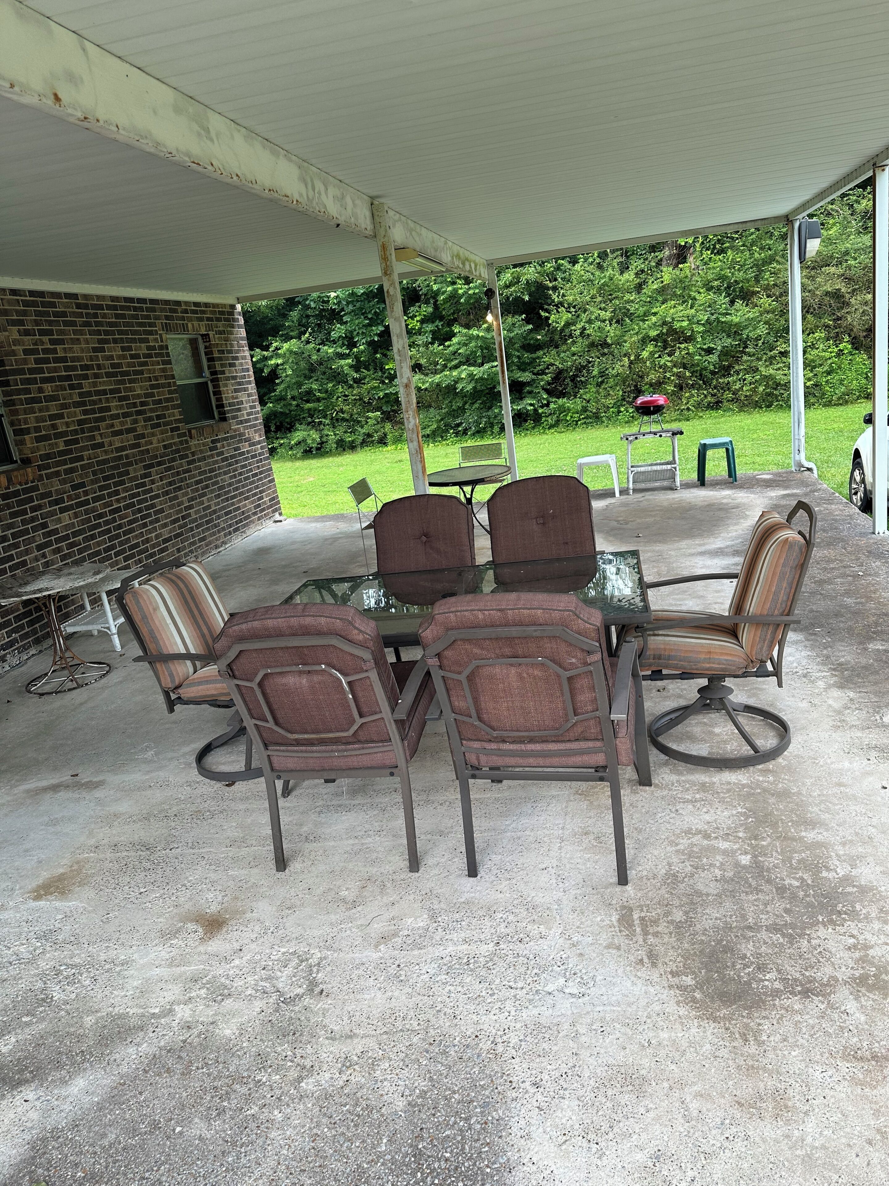 A covered outdoor seating area with a brick wall, a table, and chairs.