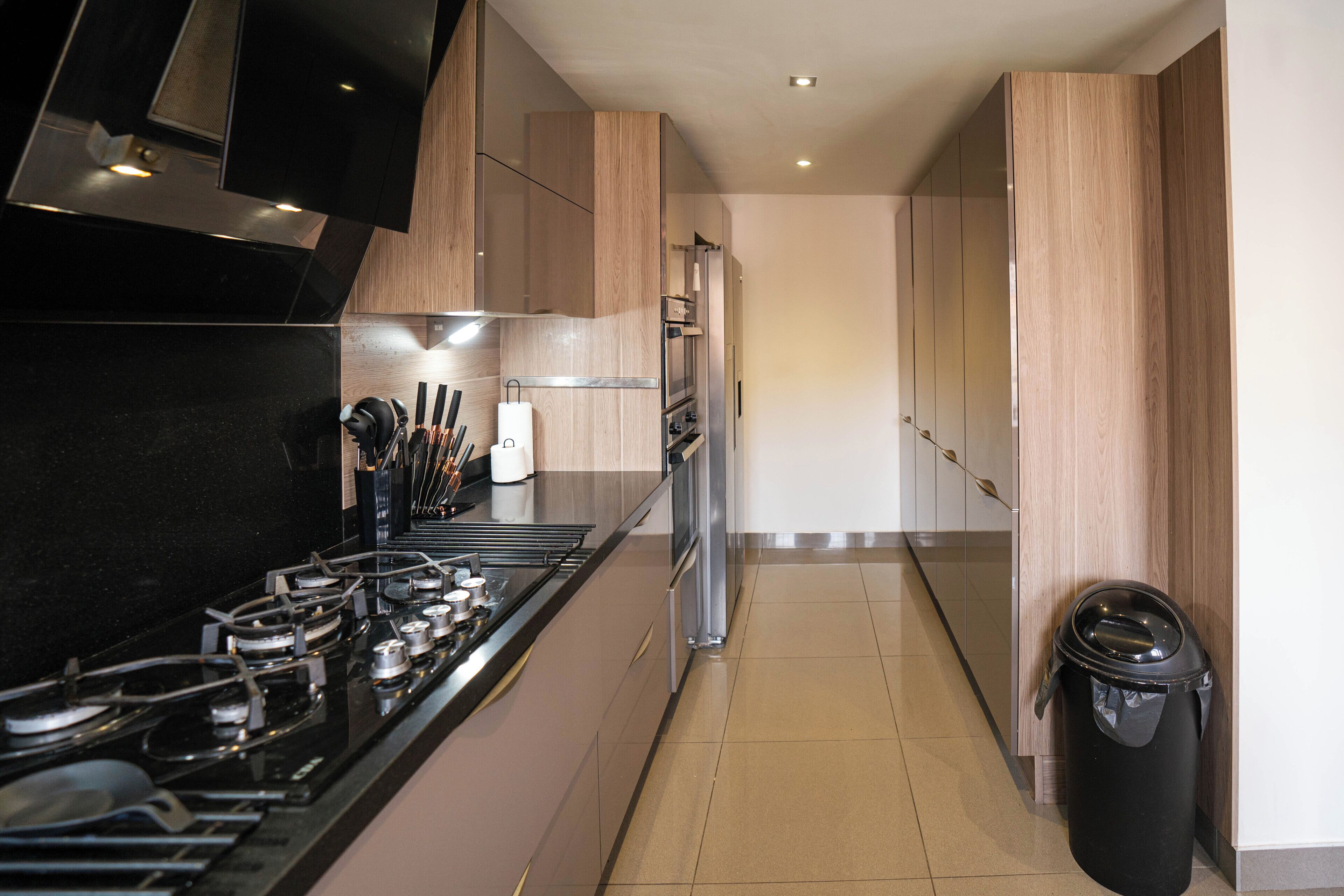 A modern kitchen with a gas stove, oven, and refrigerator.
