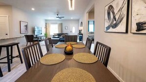 A dining area with a long table, chairs, and woven placemats. - All king beds, bike garage, Near Back 40 (Bella Vista)