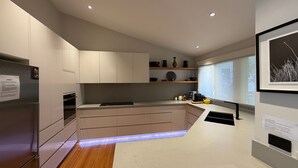 Una cocina moderna con electrodomésticos integrados, una isla central y un ventanal con vistas.