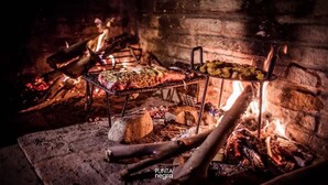 En traditionell matlagningsplats med en tegelugn och kött som tillagas genom att roteras på ett spett.