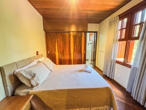 Ein Schlafzimmer mit einem Bett, einem Holzschrank und einem Fenster mit Vorhängen.