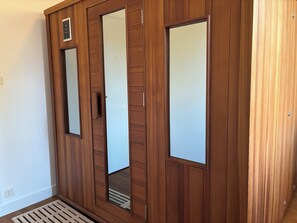 A wooden wardrobe with mirrored doors and a small shelf. - Villa Corrèze Aventure (Meymac)