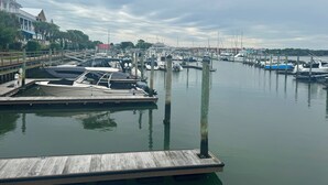 Un port de plaisance avec des bateaux amarrés, des quais en bois et une surface d’eau calme.