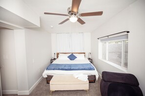 A bedroom with a bed, a ceiling fan, a window with blinds, and a chair. - Fun Compound! EV charger, mini-golf, pool, B-ball, Work station, BBQ & Laundry (Tucson)