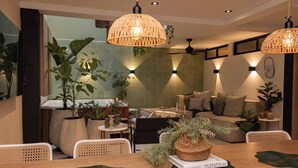A modern living room with a sofa, dining table, and hanging rattan lamps. - Poblado 12 Bedroom,  2 Jacuzzis, Rooftop, Staffed (Medellín)