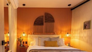 A hotel room with a large bed, two bedside tables, a mirror, and a decorative arch above the bed. - Poblado 12 Bedroom,  2 Jacuzzis, Rooftop, Staffed (Medellín)