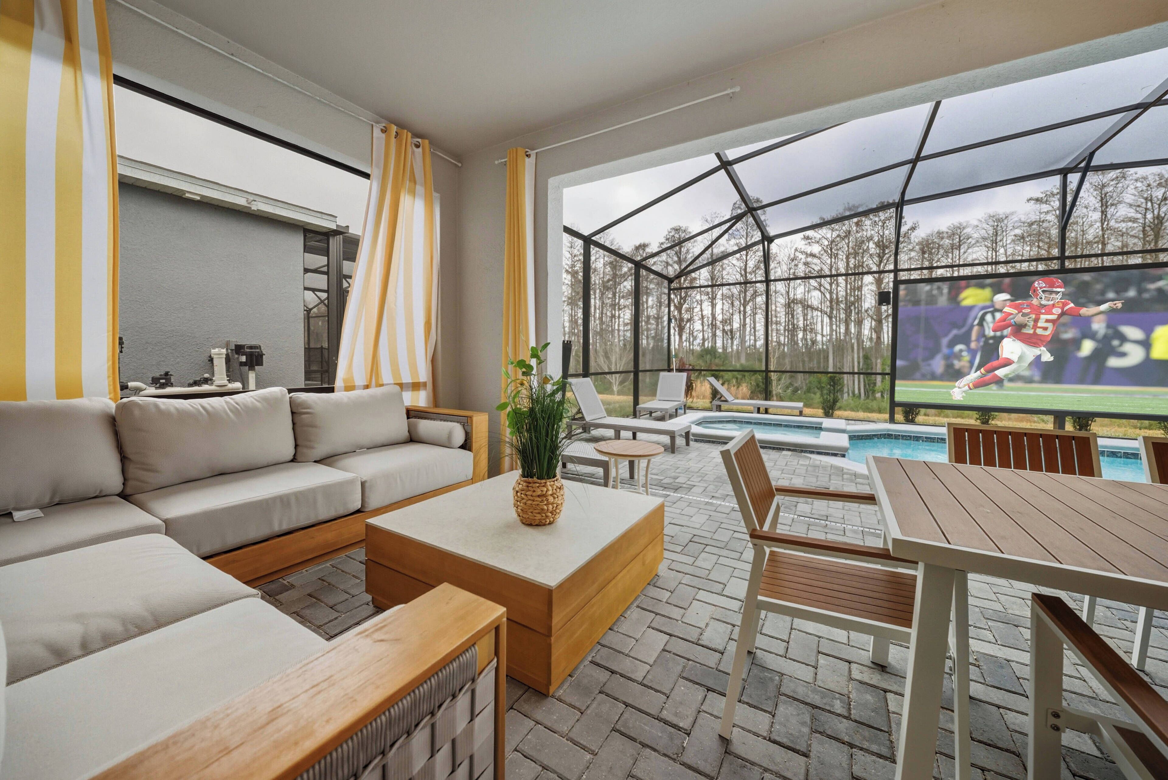 Ein modernes Wohnzimmer mit einer Eckcouch, einem Couchtisch und einem Fernsehbildschirm, der ein Sportspiel zeigt.